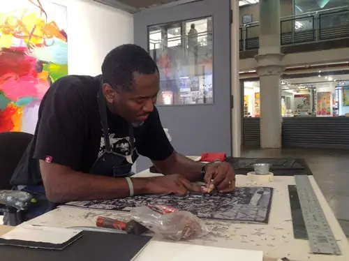 Visiting Artist Steve Prince at work his series of linoleum prints and drawings, “The Old Testament.”